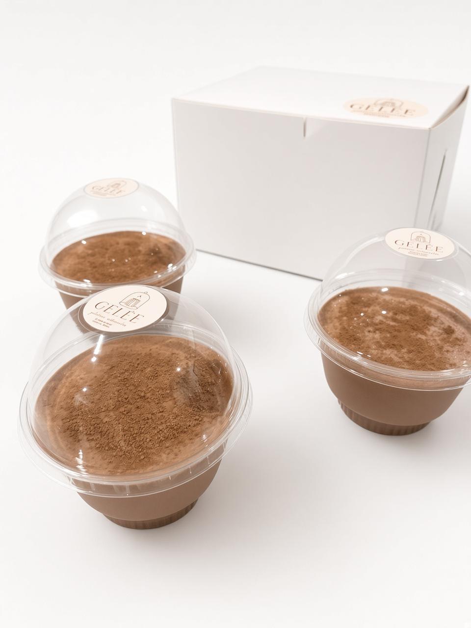 Tres gelatinas GELÉE sabor chocolate Abuelita espolvoreadas con cacao, junto a su caja