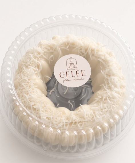 Gelée grande sabor coco, en forma de rosca cubierta de coco rallado, dentro de su envase redondo