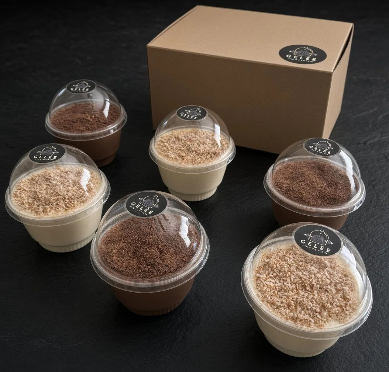 Seis gelées altos en proteína, tres de chocolate y tres de coco, alrededor de la caja de la línea